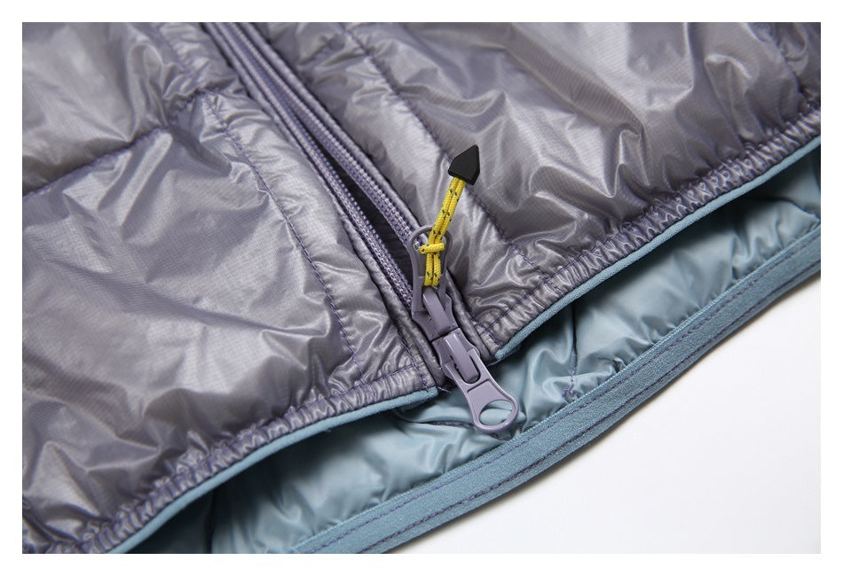 Close-up of the gray jacket's two-way zipper, yellow pull cord, pale blue lining, and hem edging.