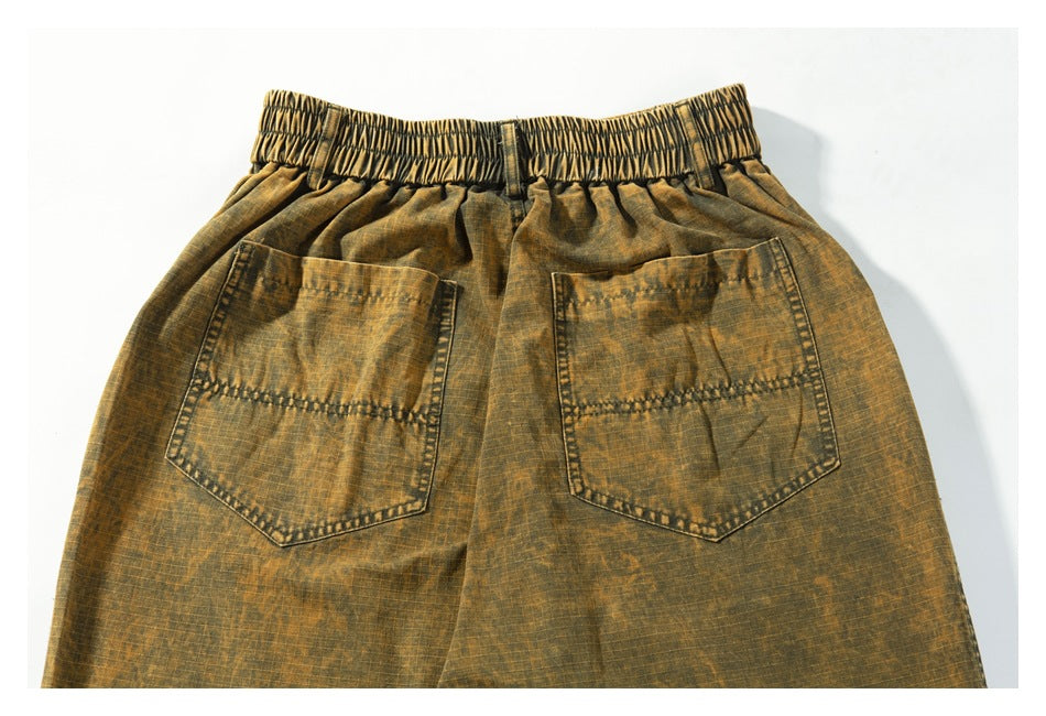 Back view of ochre-brown mottled pants with an elastic waist and two patch pockets.