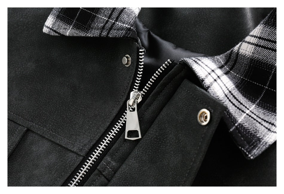 Close-up of a black garment's silver zipper, snap fasteners, and black-and-white plaid collar.