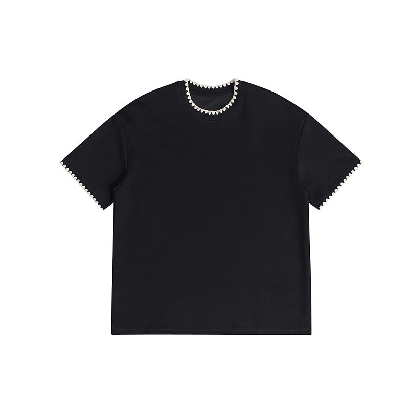 Black short-sleeve crew-neck tee with cream scalloped embroidered trim at the neckline and sleeve hems, flat lay front view