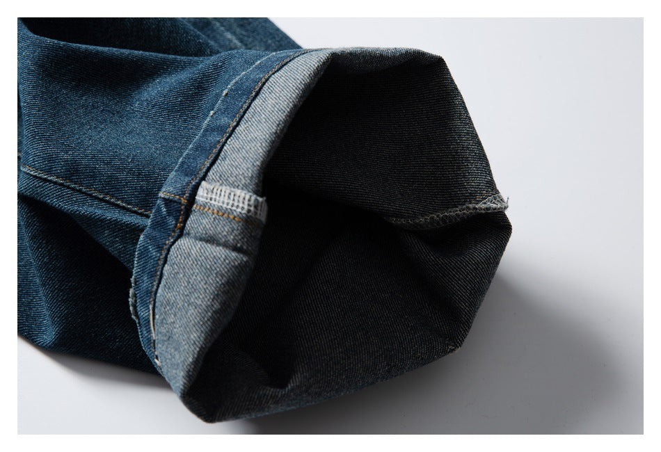 Close-up of a turned-up jeans leg opening, showing the dark inner denim and stitched hem.