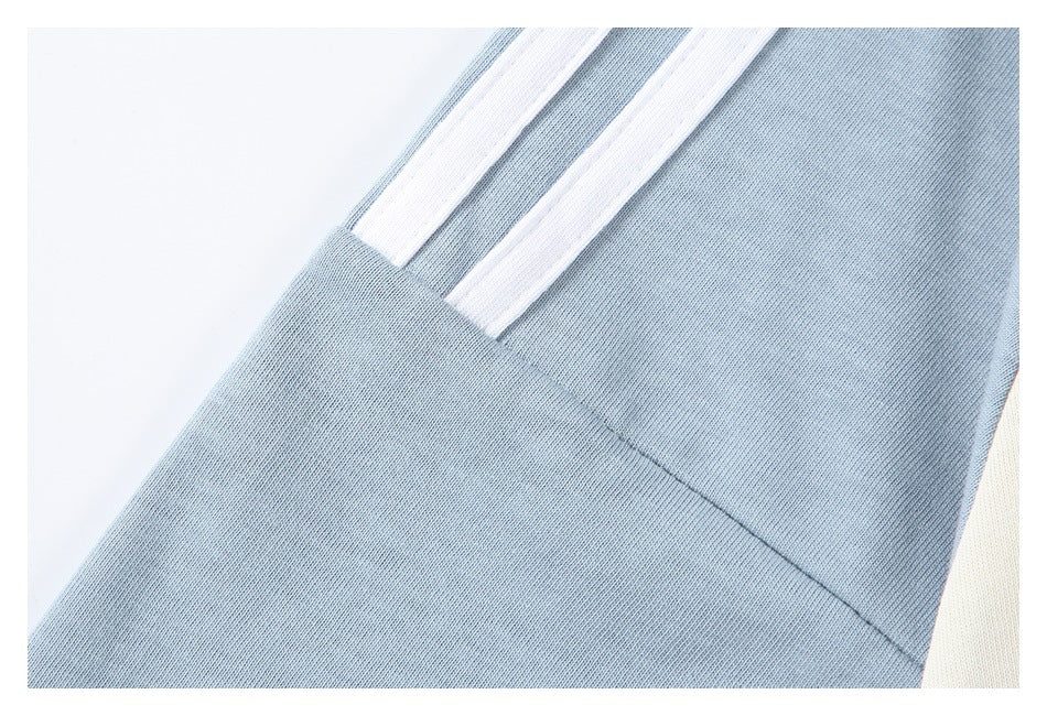 Close-up of pale blue sleeve fabric, seam, and parallel white stripes on an ivory T-shirt.