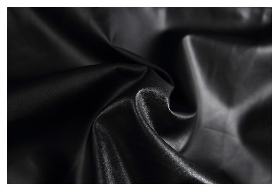 Macro close-up of glossy black jacket material folded to show its smooth surface and texture.