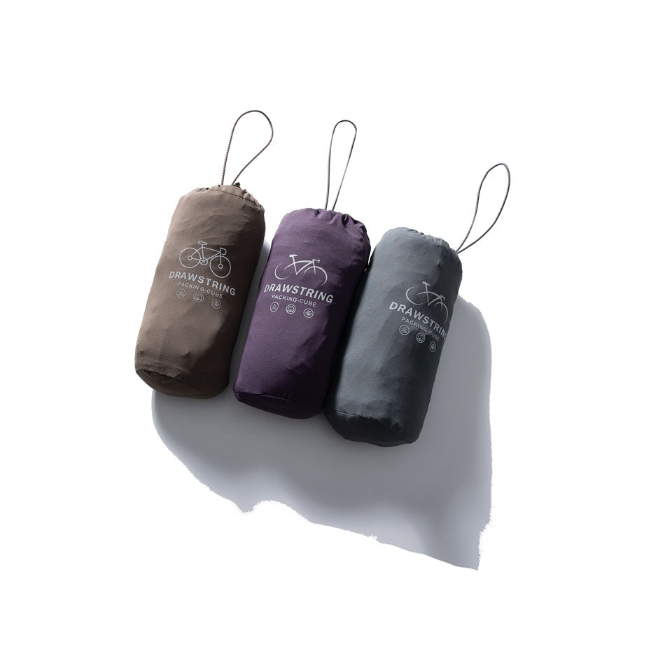 Three drawstring packing pouches in taupe, purple and charcoal, printed with bicycle graphics and English text.
