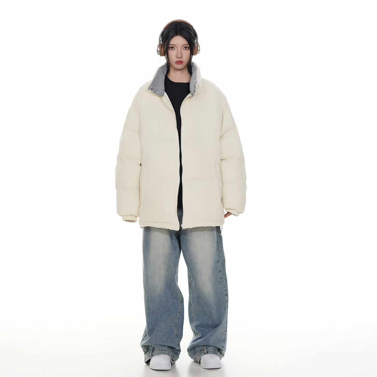 Full-length front view of a model wearing an ivory puffer jacket with a gray-lined collar.