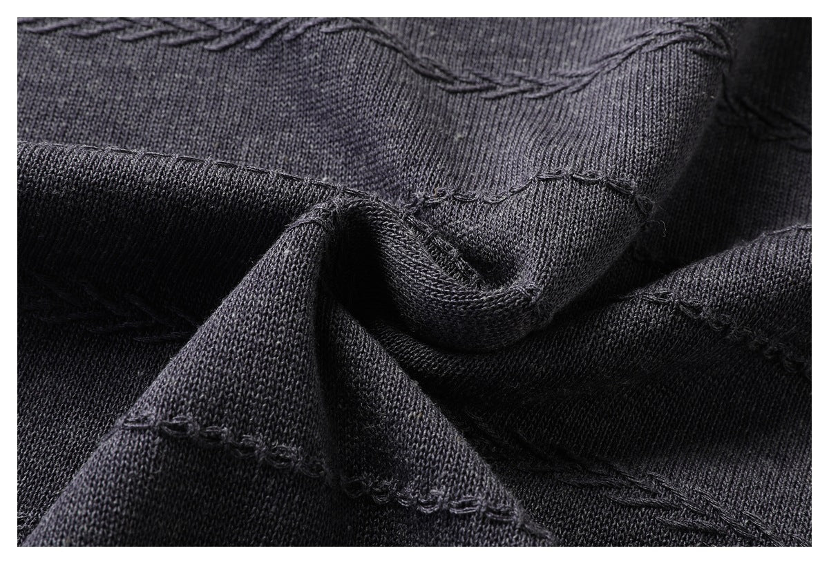 Draped charcoal knit fabric with raised decorative stitching and visible knit texture.