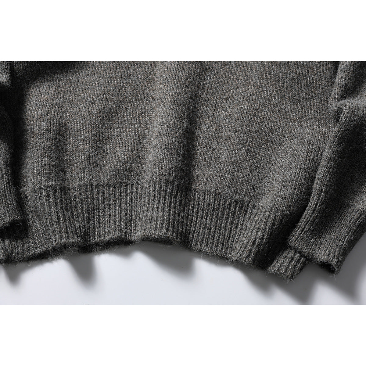 Close-up of the gray cardigan's ribbed hem and sleeve cuff.