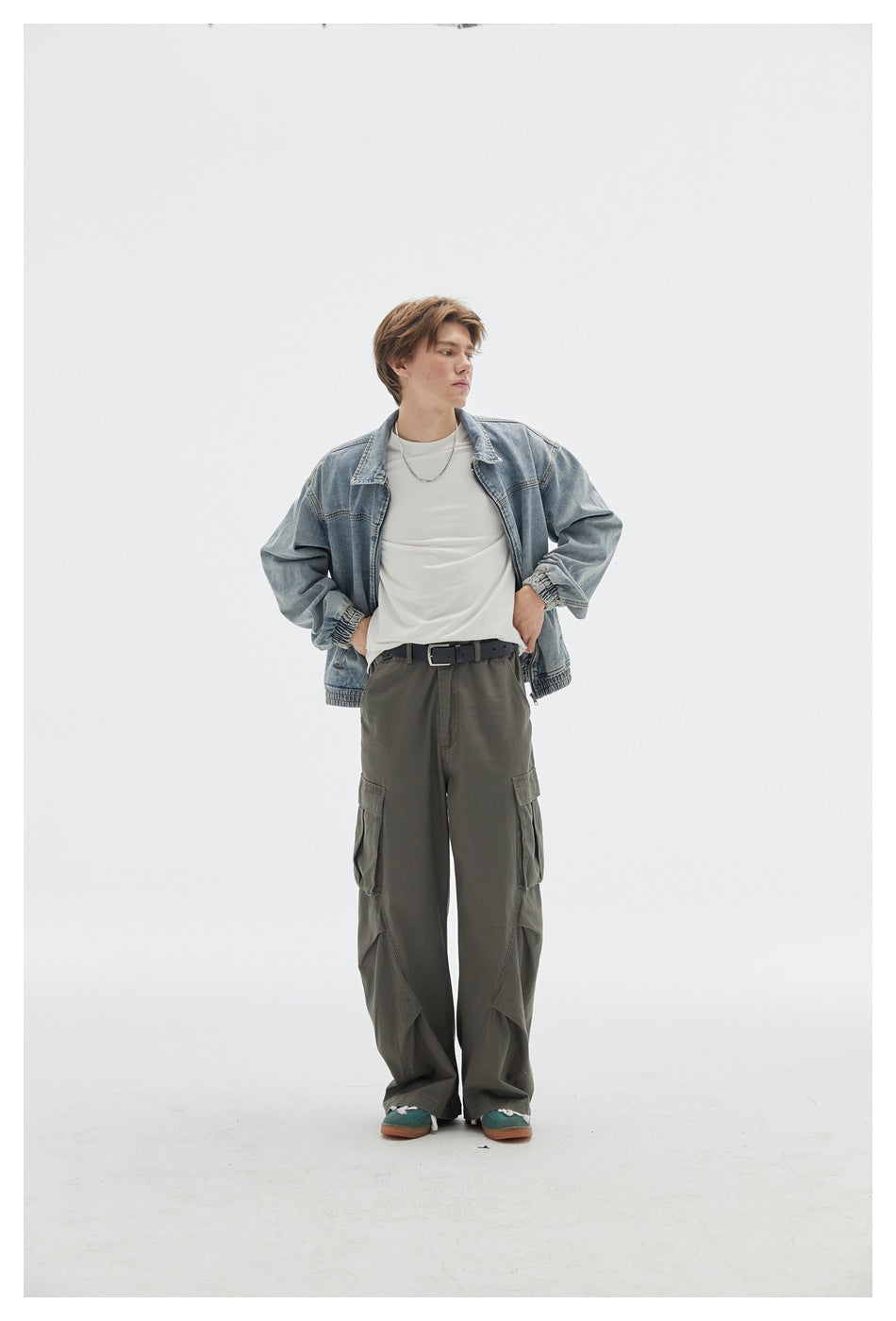 Model wearing an open light blue denim jacket with gathered cuffs and hem, a white shirt, and olive cargo pants.