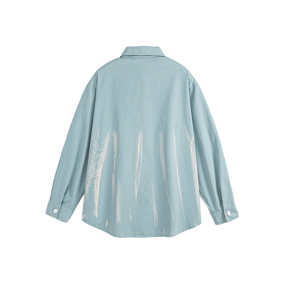 Back view of a light blue long-sleeve button-up shirt with white brushstroke graphics across the lower back.