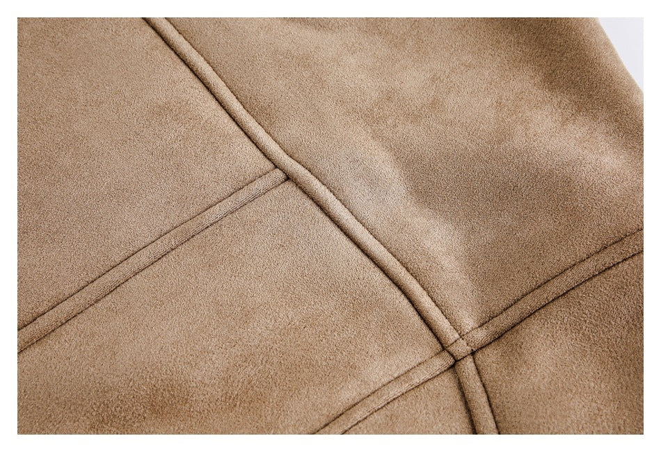 Close-up of a tan coat with intersecting stitched seams across its fabric panels.