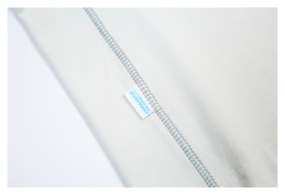 Close-up of an off-white garment's overlock seam and a small sewn-in brand tab.