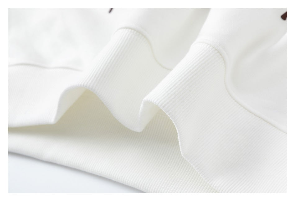 Close-up of a wide ribbed white garment hem folded into soft waves.