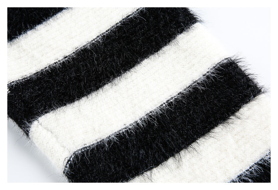Close-up of fuzzy black-and-ivory knit fabric with broad stripes.