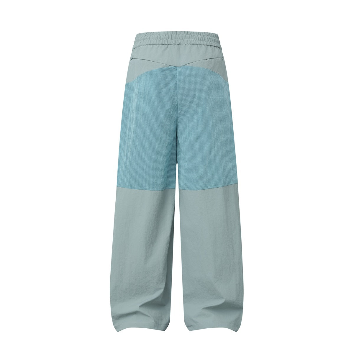 Back view of teal-green wide-leg pants with a light blue ripstop-style grid panel across the seat and upper thighs