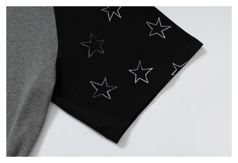 Close-up of a black garment panel with outlined star motifs beside gray fabric.