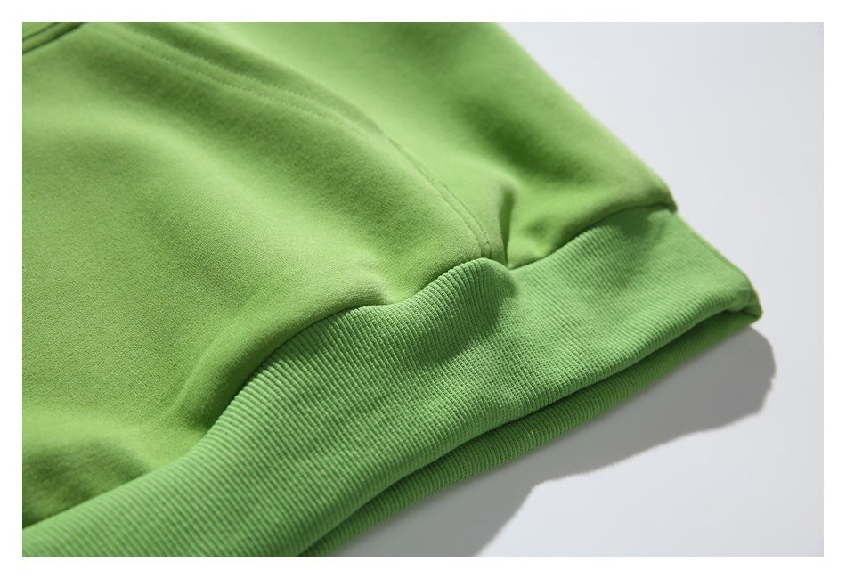 Close-up of the green hoodie’s ribbed bottom hem and gathered fabric.