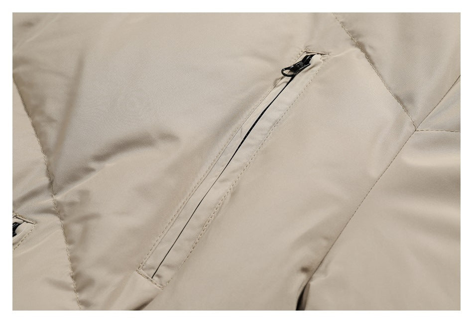 Close-up of a beige jacket's diagonal zip pocket with a black zipper.