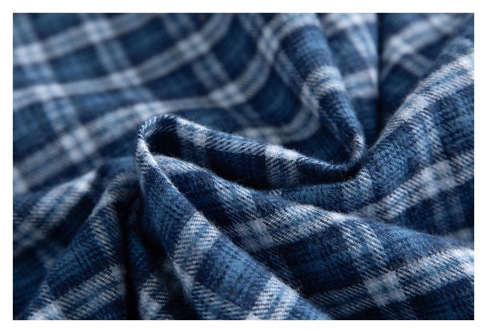 Close-up of draped navy and gray plaid fabric with a visible woven pattern and soft texture.