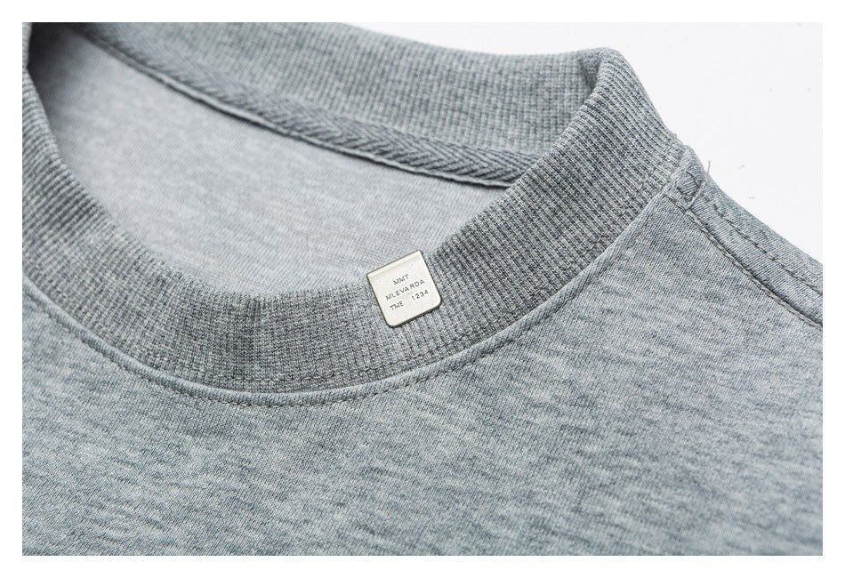 Close-up of the ribbed crew neckline and small interior label on a heather gray sweatshirt.