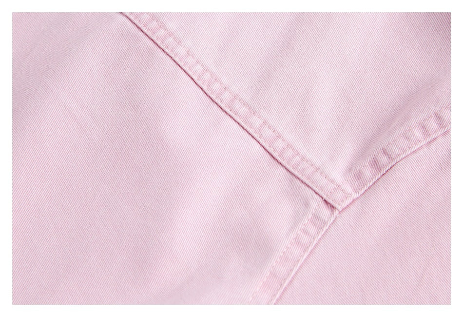 Close-up of pink garment fabric showing intersecting stitched seams.