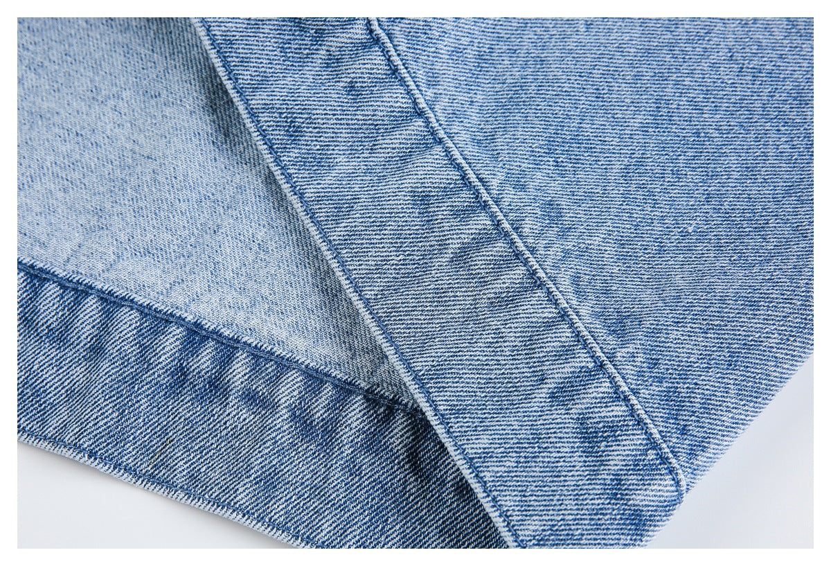 Close-up of overlapping light blue denim panels with contrasting seams and faded areas.