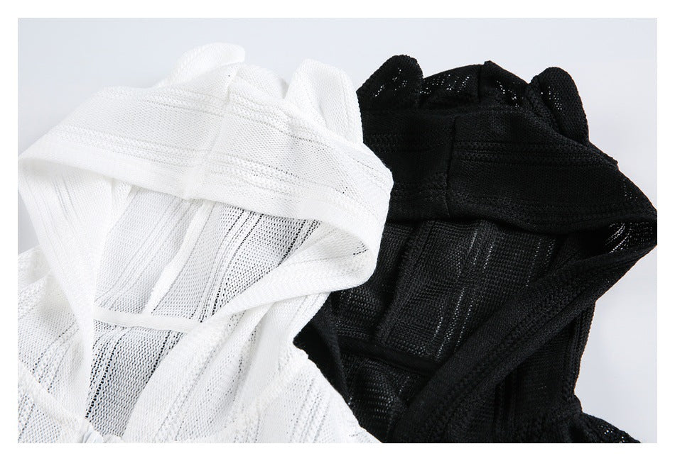 Close-up of white and black knit hoodies showing textured panels and raised hood details.