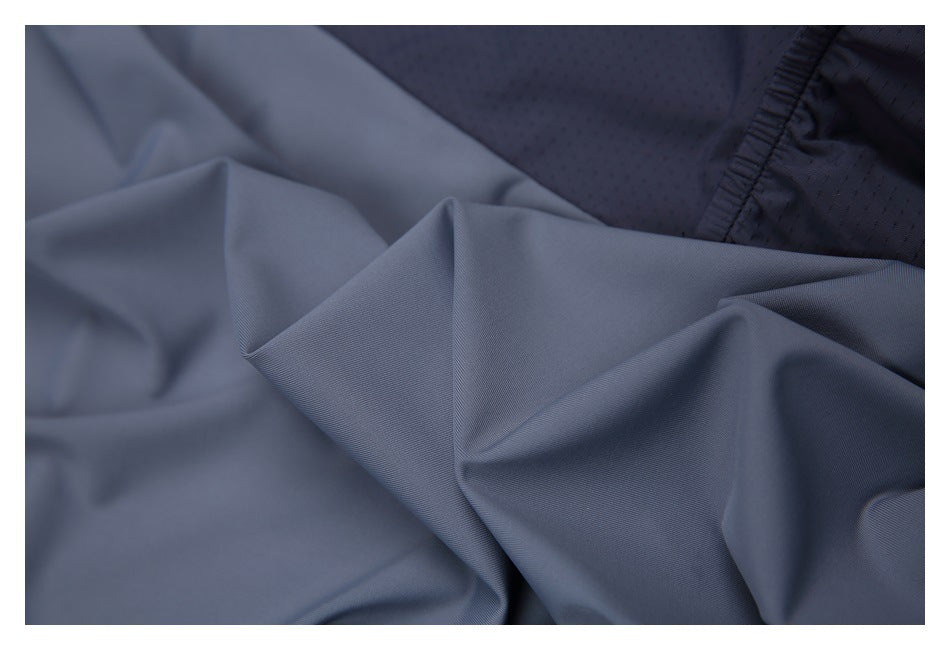 Close-up of slate-gray fabric beside a dark perforated panel.