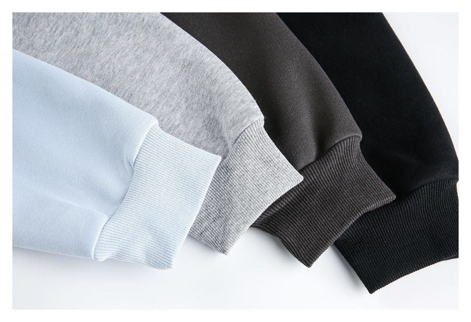 Close-up of ribbed cuffs on pale blue, heather gray, charcoal, and black jackets.