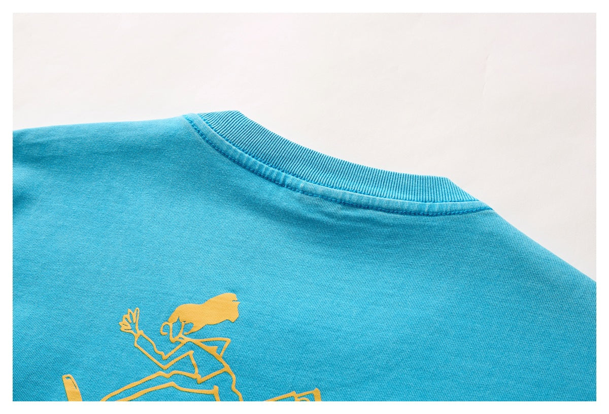 Close-up of the back neckline and partial yellow graphic on a turquoise T-shirt.