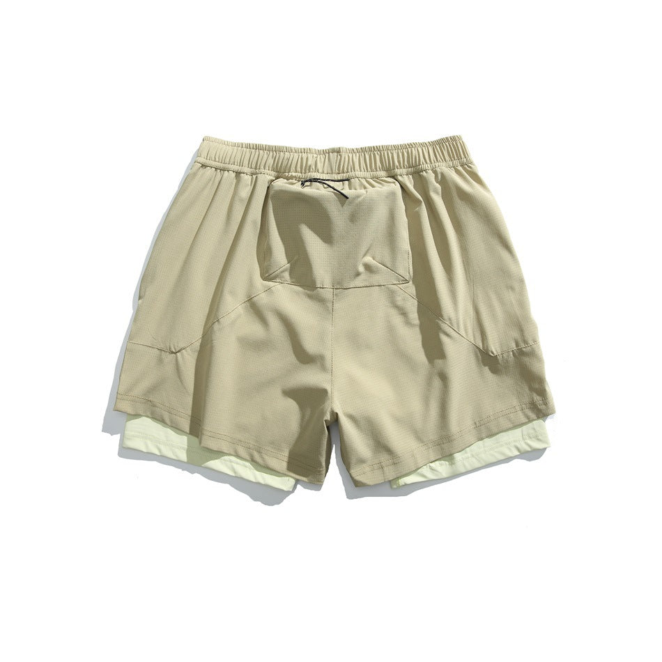 Pale beige layered athletic shorts, back view, with an elastic waistband, center rear pocket and light inner shorts.