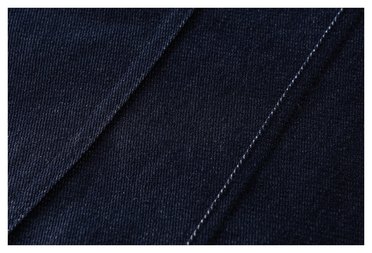 Close-up of dark navy fabric with diagonal stitched seams.