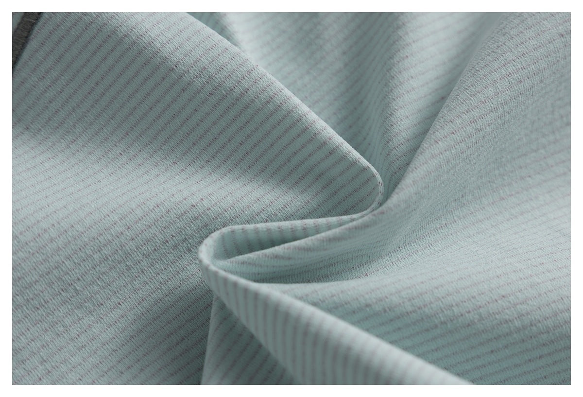 Close-up of softly folded pale mint-gray fabric with fine, subtle stripes.
