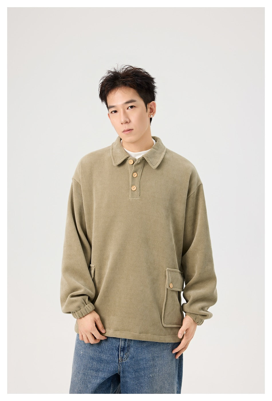 Model wearing an olive-beige collared pullover with a three-button placket and flap pockets.