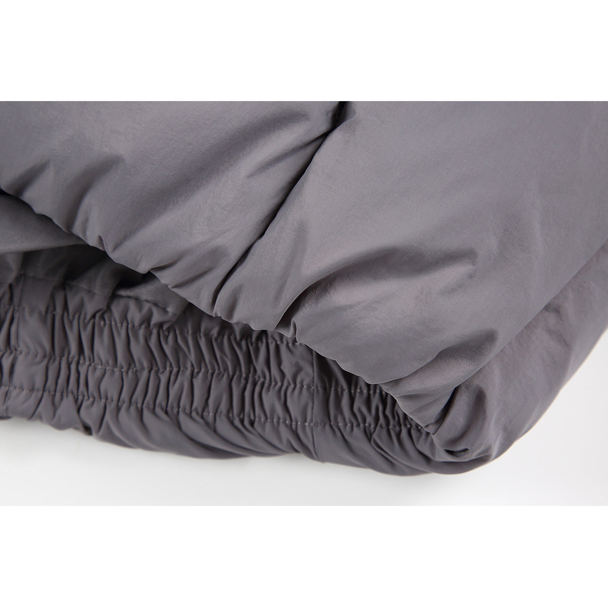 Close-up of the gray jacket's gathered elastic hem and padded fabric.