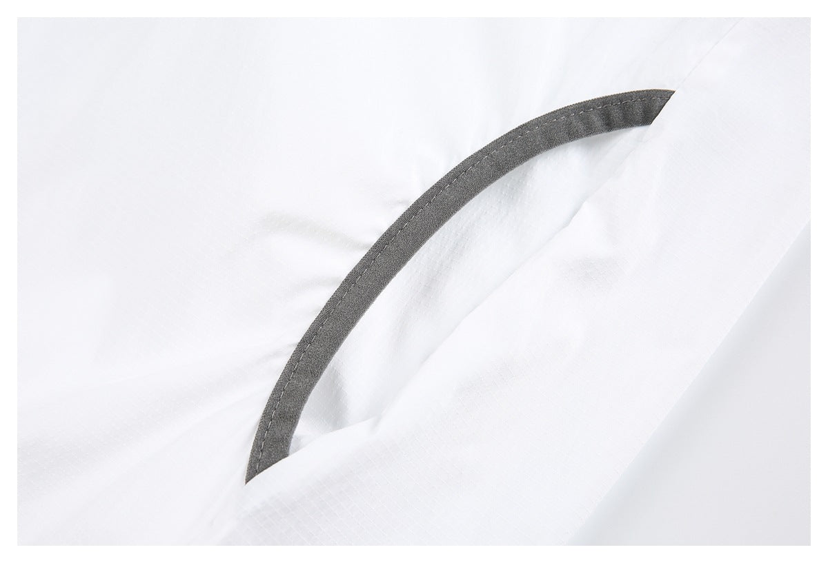 Close-up of a curved dark gray-trimmed opening on white fabric.