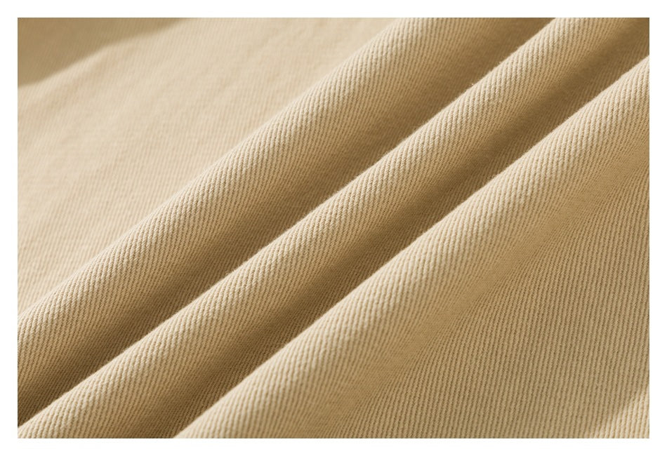Close-up showing the diagonal weave and texture of beige garment fabric.