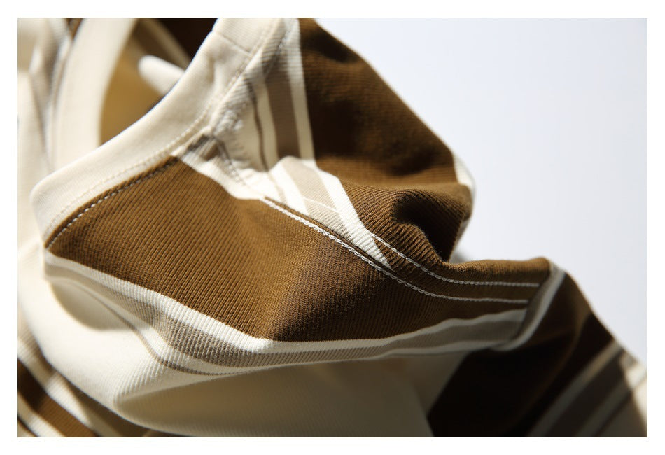 Close-up of cream and brown striped fabric with visible stitching and folded edges.