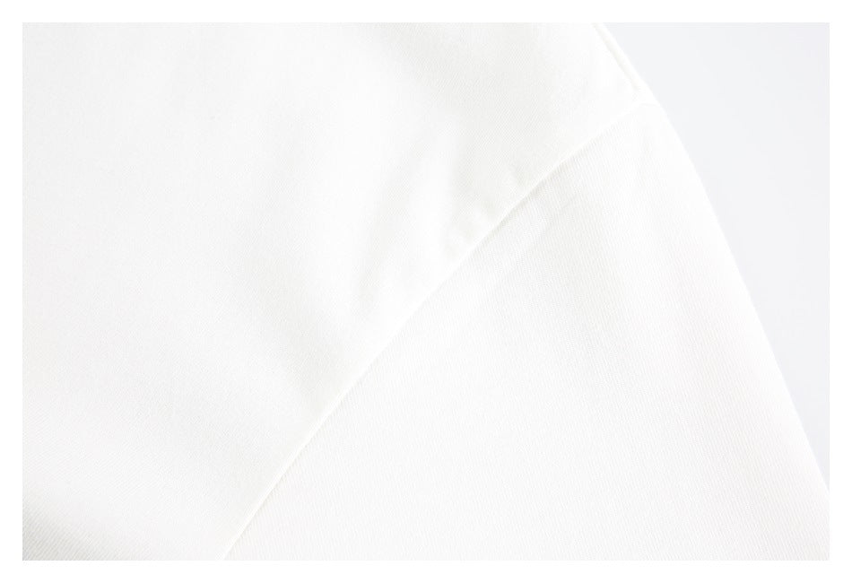 Close-up of white garment fabric with a diagonal fold and seam.