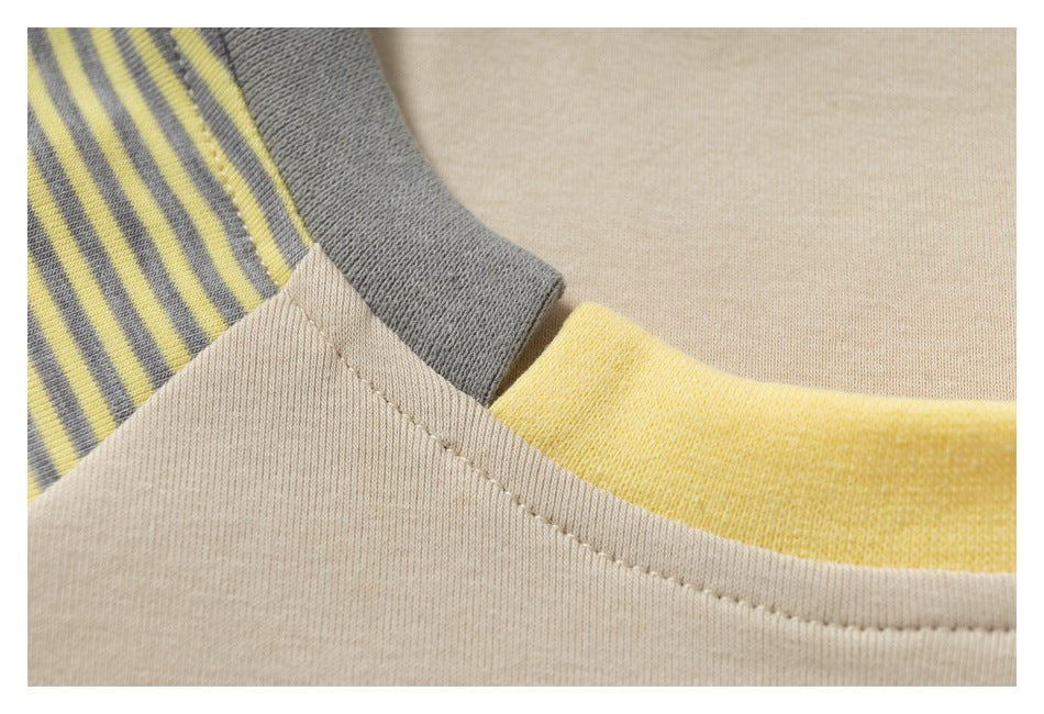 Close-up of the beige shirt neckline seam beside a gray collar section and yellow-gray striped sleeve.