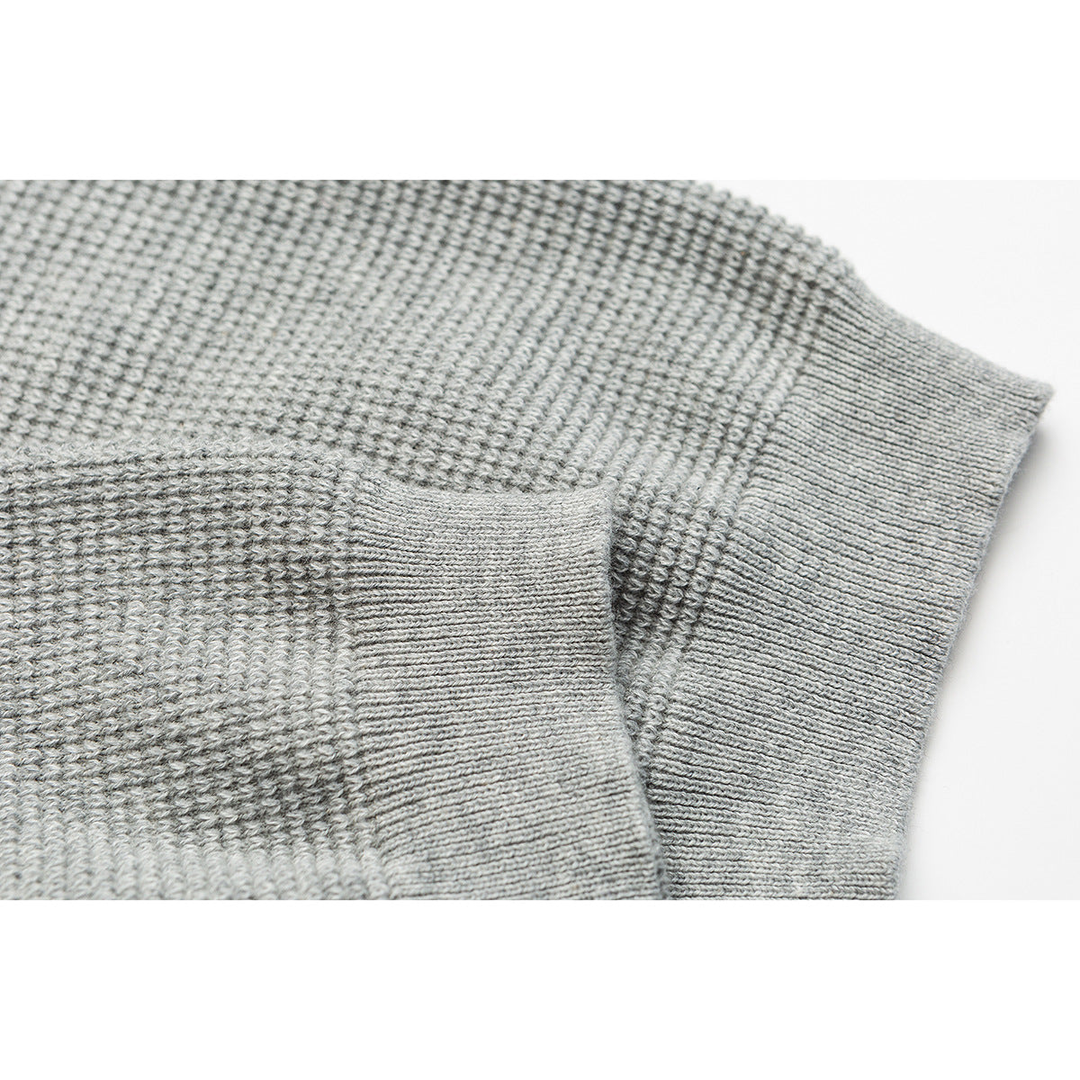 Close-up of the gray knit top's short sleeve and ribbed cuff.