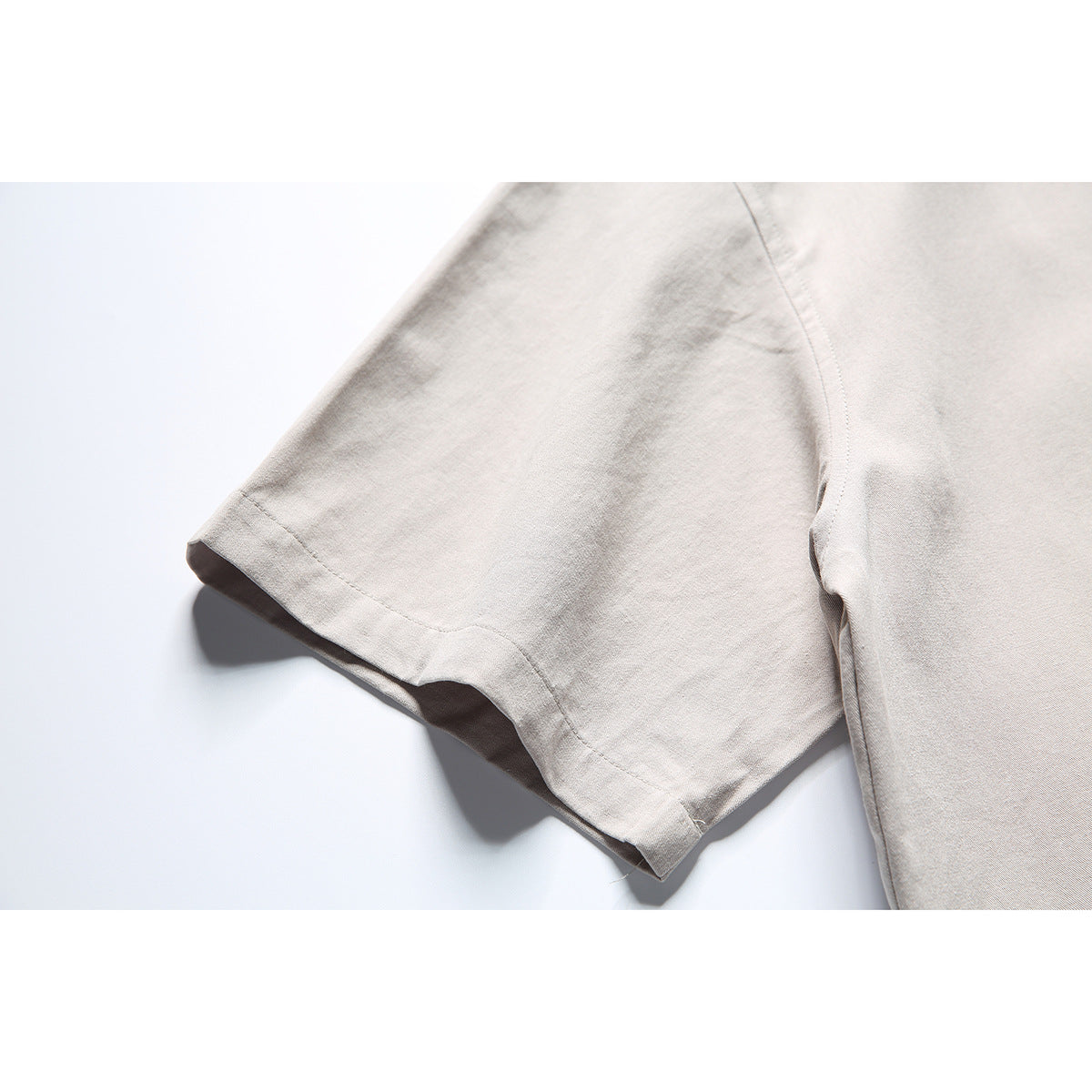 Close-up of a light gray short sleeve and its stitched hem.