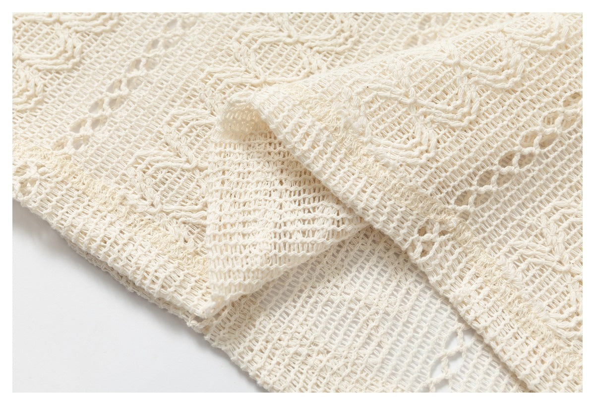Close-up of overlapping cream open-knit fabric, showing its patterned weave and openwork.