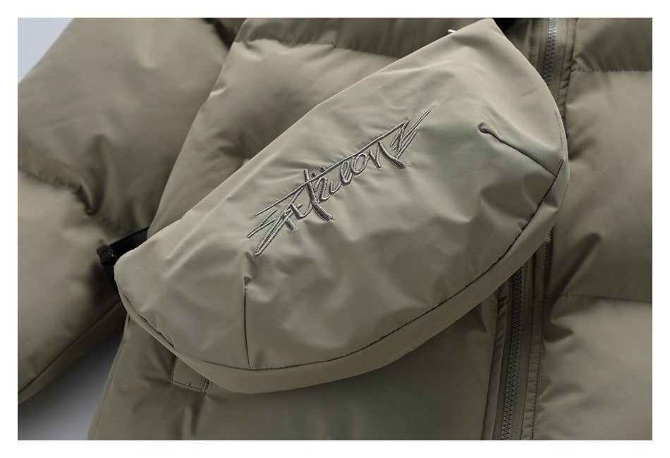 Close-up of the matching gray-green crossbody bag with embroidered script and a curved flap.