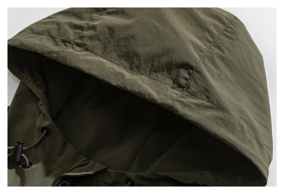 Close-up of an olive hood with stitched panels and an adjustable drawcord.