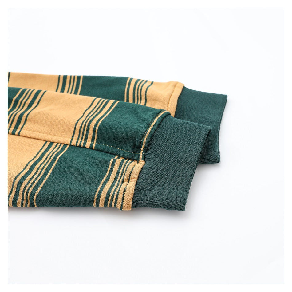 Close-up of dark green ribbed cuffs on a mustard and dark green striped garment.