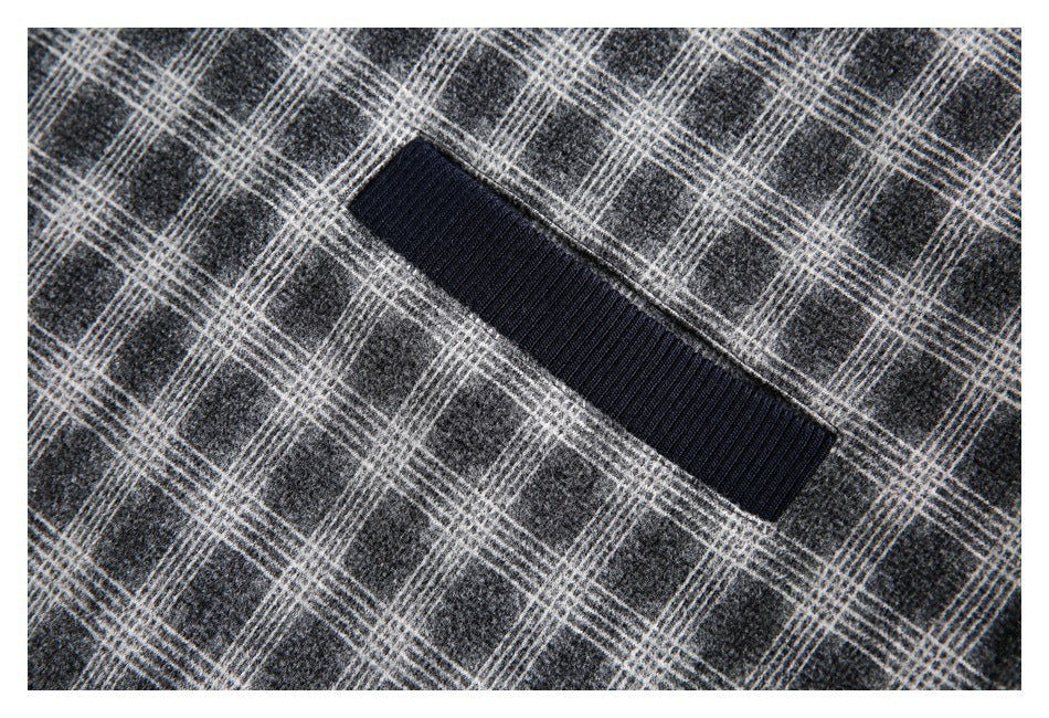 Close-up of a dark ribbed rectangular trim on charcoal gray plaid fabric.