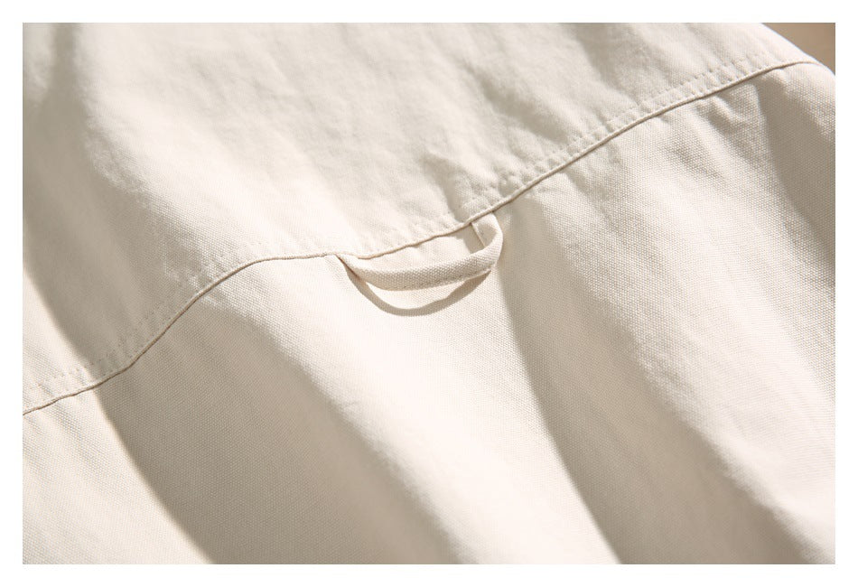 Close-up of the beige jacket's back yoke seam and small hanging loop.
