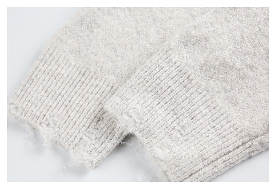 Close-up of an ivory fuzzy knit sweater with a wide ribbed cuff or hem.