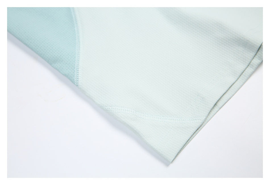 Close-up of a pale mint shirt hem and curved seam beside a perforated side panel.