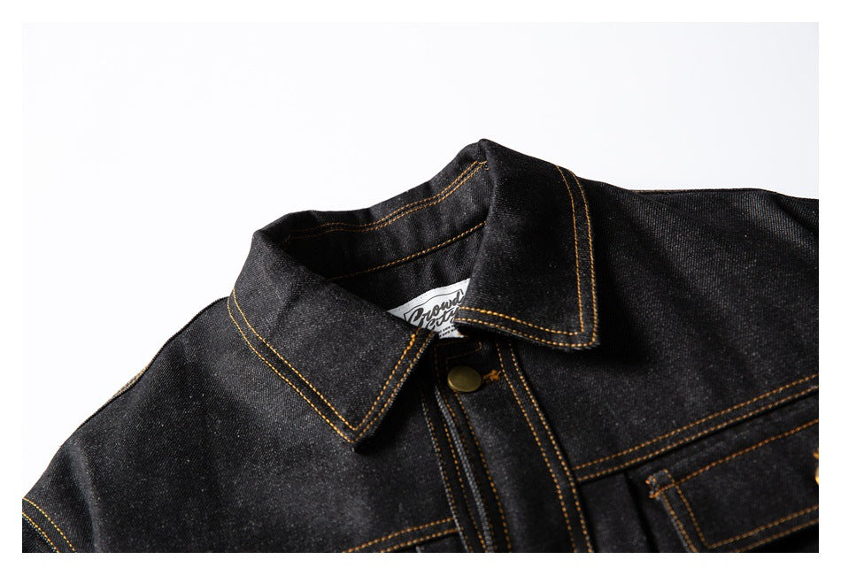 Close-up of the dark denim jacket collar, upper front, and golden contrast stitching.